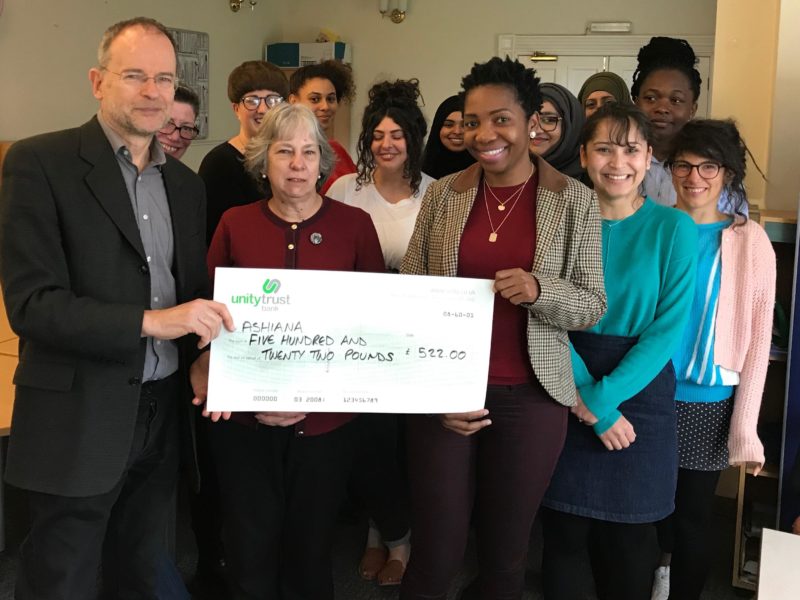 Paul is presenting a giant cheque to Ashiana staff and volunteers.